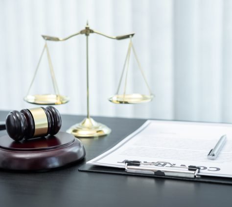 Judge gavel with Justice at law firm in background with legal case document contract